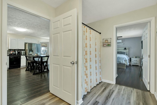 bathroom with a shower with shower curtain, wood-type flooring, and a textured ceiling