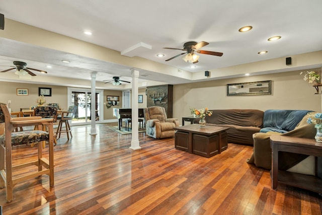 living room featuring dark wood-type flooring and decorative columns