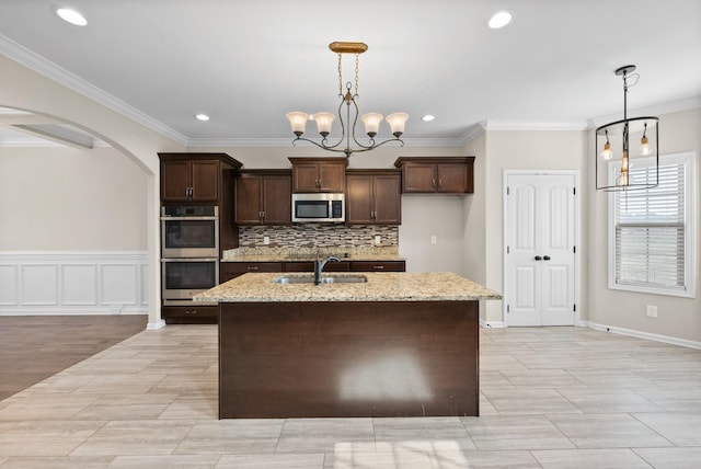 kitchen featuring an inviting chandelier, crown molding, sink, appliances with stainless steel finishes, and light stone counters