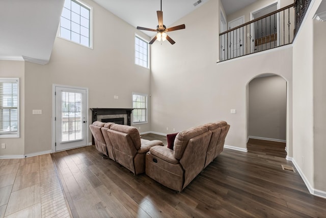 living room featuring a high ceiling, dark hardwood / wood-style floors, and ceiling fan