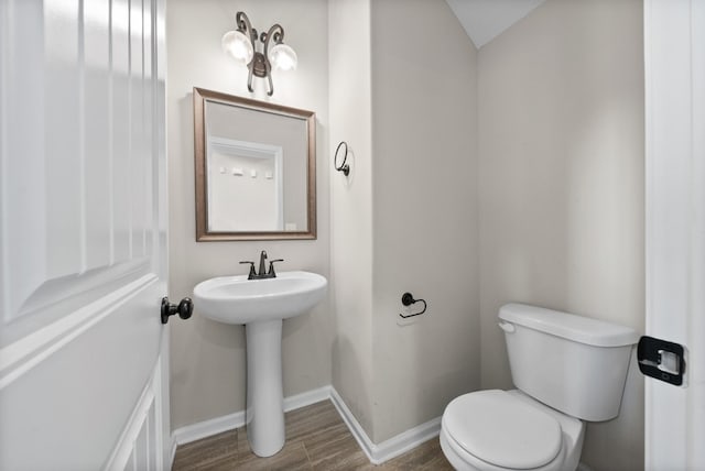 bathroom featuring toilet, lofted ceiling, and hardwood / wood-style flooring