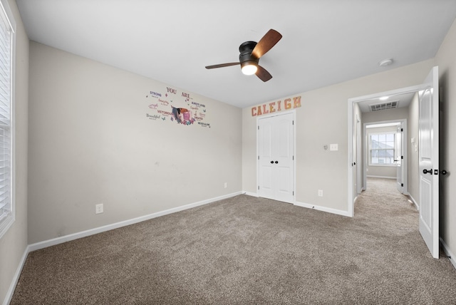 unfurnished bedroom featuring ceiling fan, light colored carpet, and a closet