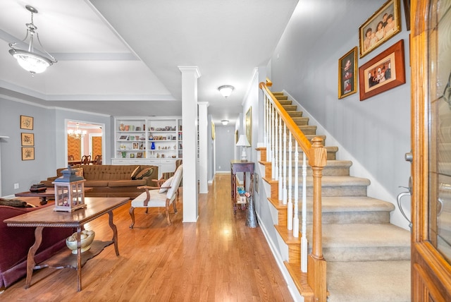 interior space with hardwood / wood-style floors, an inviting chandelier, and decorative columns