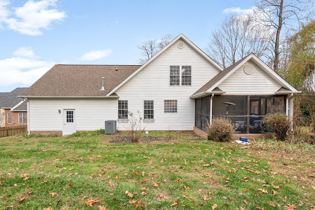 rear view of house with a lawn, central AC, and a sunroom