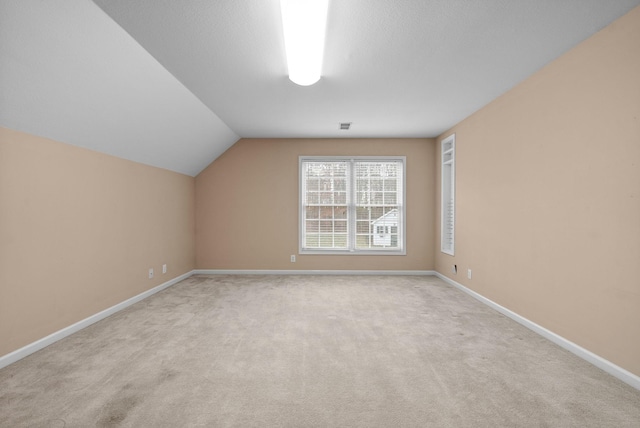 bonus room featuring light carpet and vaulted ceiling