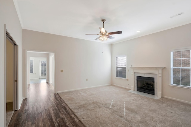 unfurnished living room with light wood-type flooring, crown molding, ceiling fan, and a healthy amount of sunlight