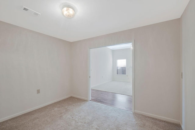 unfurnished room featuring light carpet