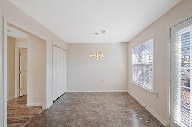 unfurnished room with a notable chandelier