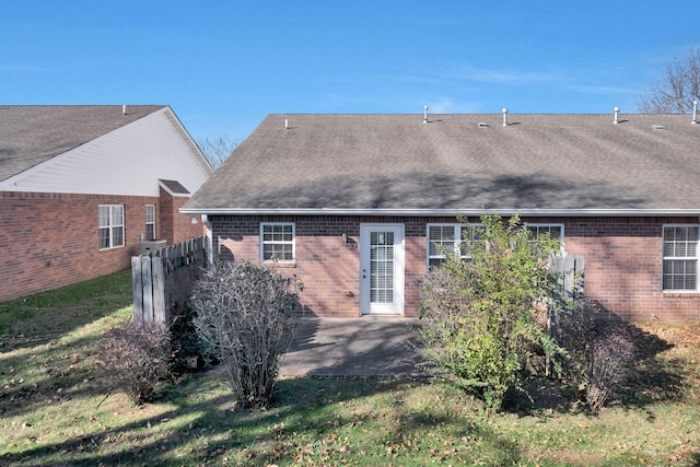 back of property with a patio area and a lawn