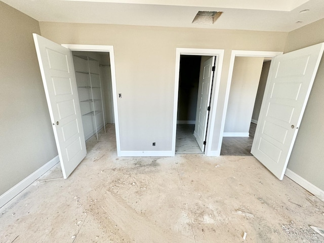 unfurnished bedroom with a walk in closet and a closet