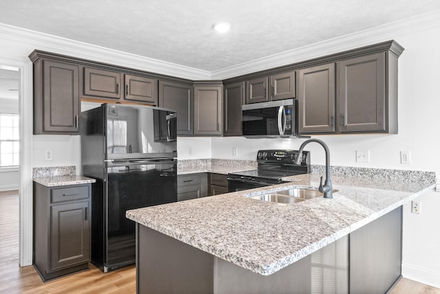 kitchen featuring kitchen peninsula, ornamental molding, sink, black appliances, and light hardwood / wood-style flooring