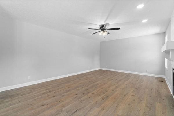 unfurnished living room featuring ceiling fan and wood-type flooring