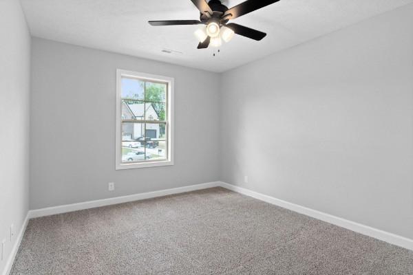 spare room with ceiling fan and carpet floors