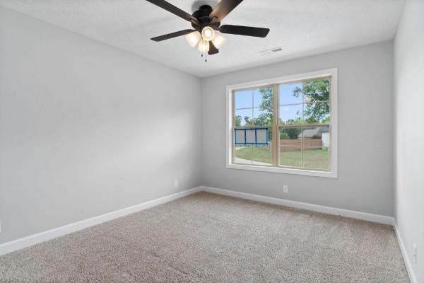 unfurnished room featuring ceiling fan and carpet