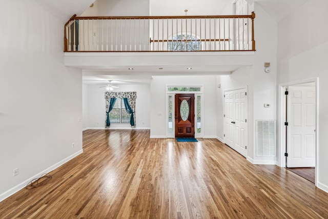 entrance foyer featuring ceiling fan, hardwood / wood-style floors, and high vaulted ceiling