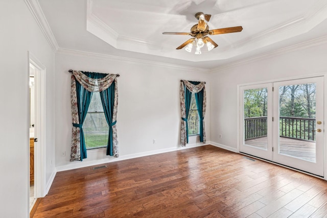 spare room featuring hardwood / wood-style floors, a tray ceiling, ceiling fan, and crown molding