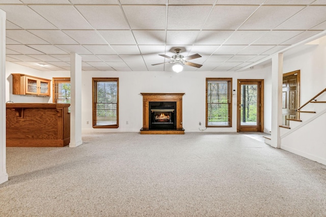 unfurnished living room featuring a paneled ceiling, light colored carpet, and ceiling fan