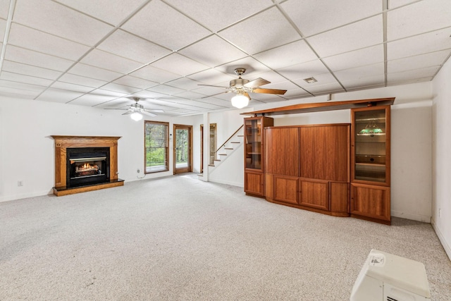 unfurnished living room with light carpet and a drop ceiling