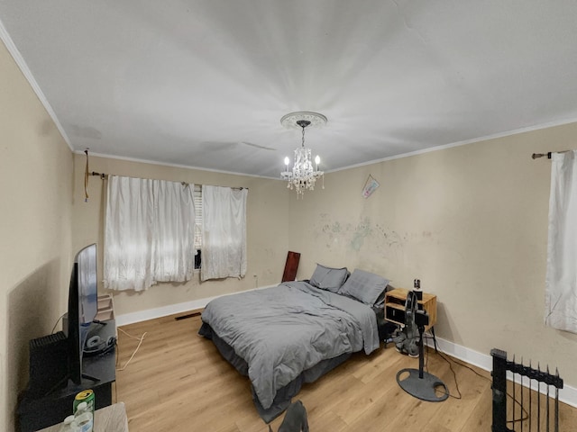 bedroom with a notable chandelier, wood-type flooring, and ornamental molding