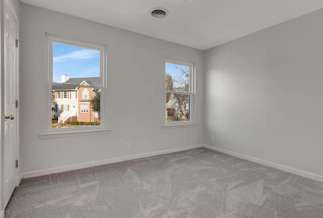 unfurnished room with light carpet and plenty of natural light