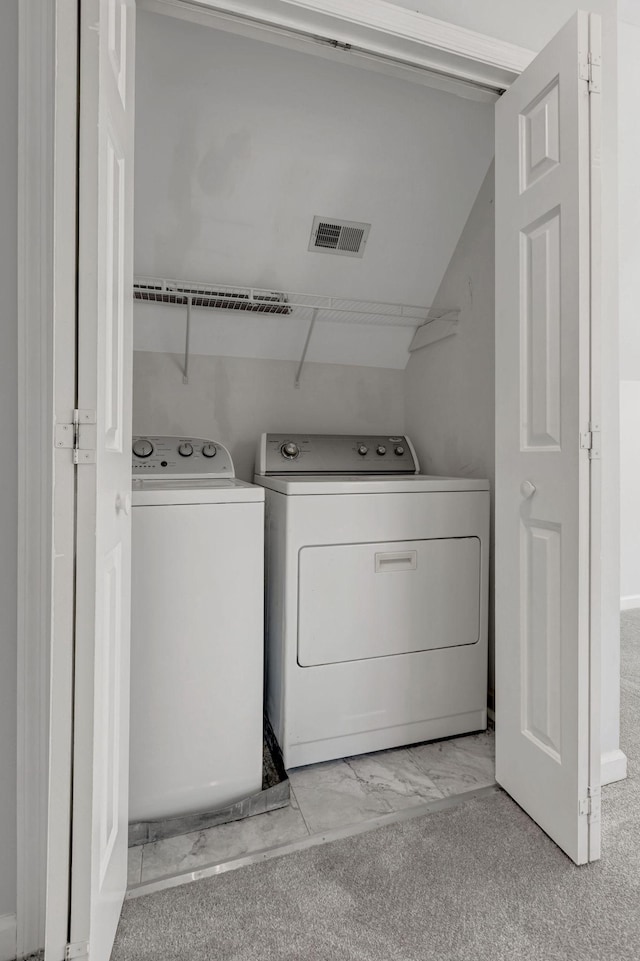 laundry room with separate washer and dryer and light carpet