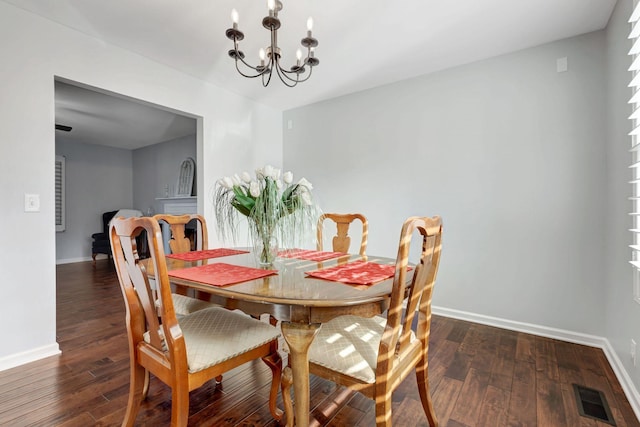 dining room featuring dark hardwood / wood-style floors and an inviting chandelier