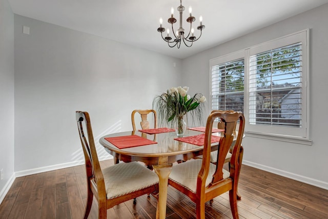 dining space featuring dark hardwood / wood-style flooring and an inviting chandelier