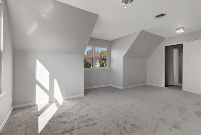 additional living space featuring light carpet and vaulted ceiling