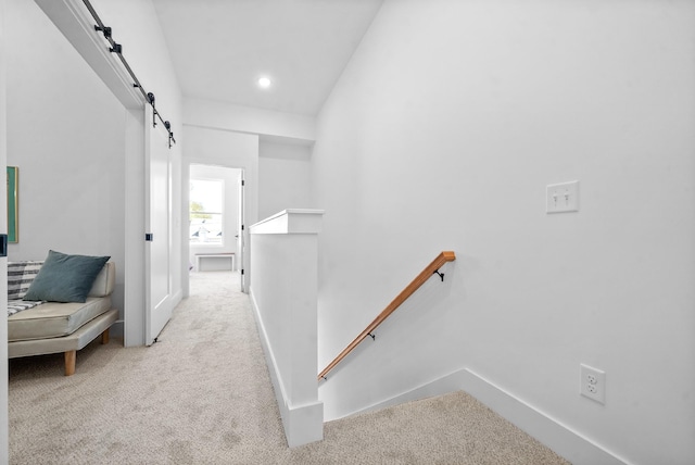 corridor featuring light colored carpet and lofted ceiling