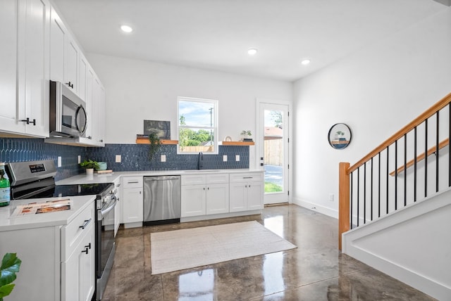 kitchen featuring stainless steel appliances, white cabinetry, tasteful backsplash, and sink