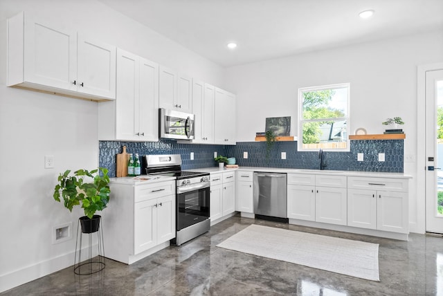 kitchen with tasteful backsplash, white cabinetry, sink, and stainless steel appliances