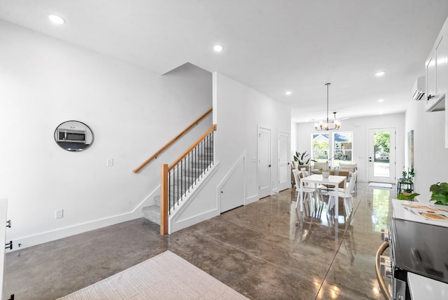 interior space featuring a wall mounted air conditioner and a notable chandelier