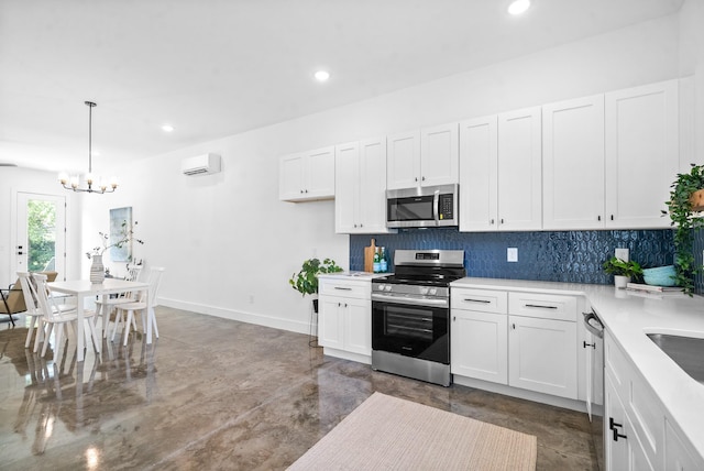 kitchen with a wall mounted air conditioner, decorative light fixtures, white cabinetry, and stainless steel appliances