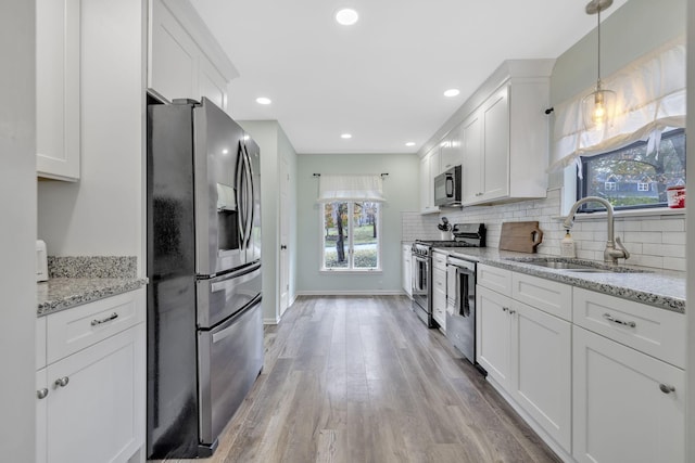 kitchen featuring light hardwood / wood-style floors, white cabinetry, sink, and appliances with stainless steel finishes