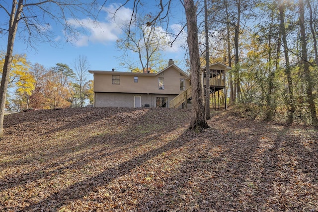 back of house with a wooden deck and a sunroom