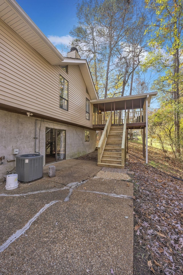 view of side of home with central air condition unit and a deck