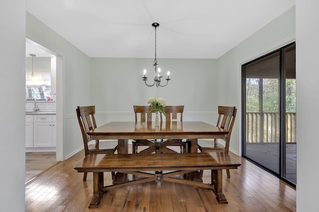 dining room featuring light hardwood / wood-style floors, sink, and a chandelier