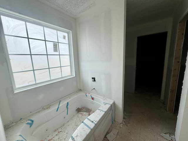 bathroom with a wealth of natural light and a tub to relax in