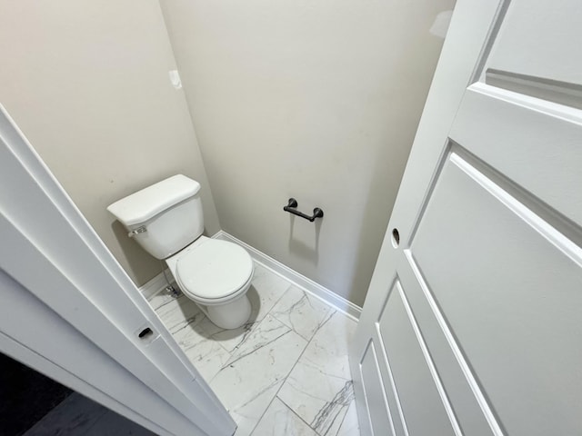 bathroom featuring marble finish floor, toilet, and baseboards