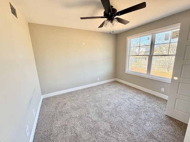 carpeted empty room with baseboards and a ceiling fan