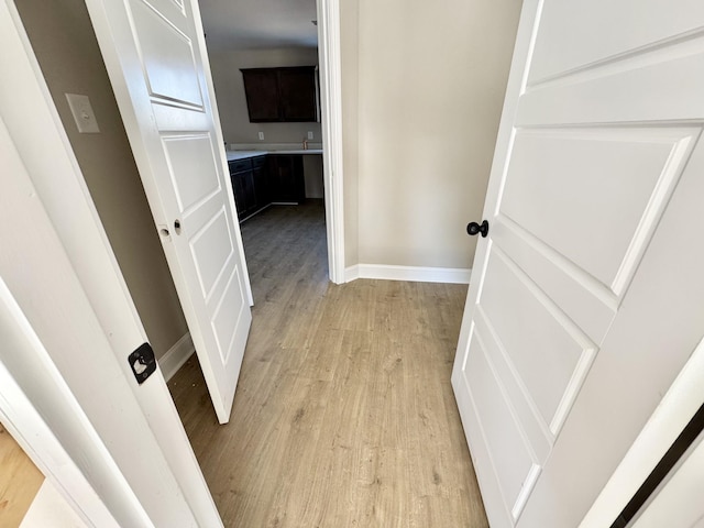 hallway with light wood finished floors and baseboards