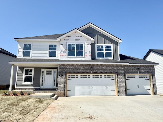 view of front of house with concrete driveway, an attached garage, brick siding, and board and batten siding