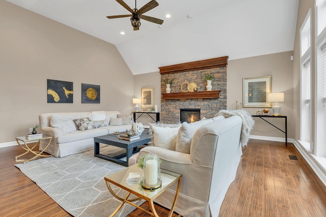 living room featuring ceiling fan, a fireplace, high vaulted ceiling, and wood-type flooring