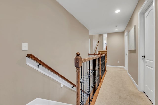 hallway featuring light colored carpet