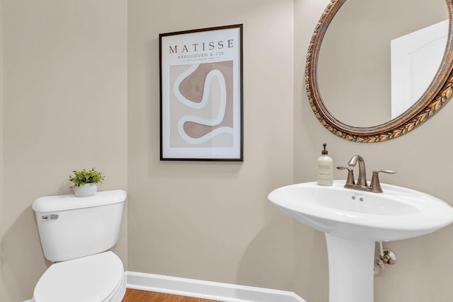 bathroom featuring toilet and wood-type flooring