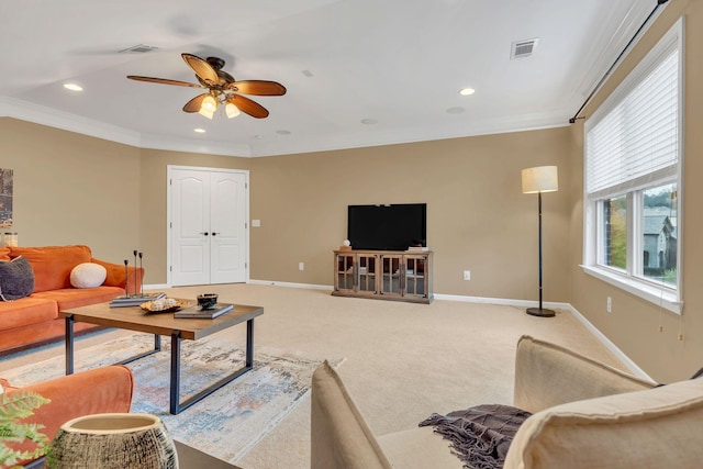 carpeted living room with crown molding and ceiling fan