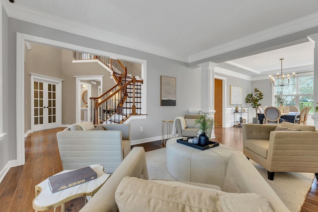 living room featuring ornate columns, crown molding, and hardwood / wood-style flooring