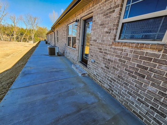 view of side of property featuring central air condition unit and a patio