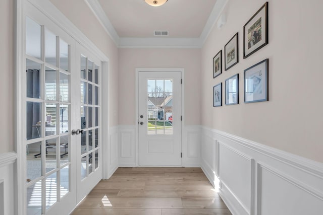 entryway featuring french doors, light hardwood / wood-style floors, and ornamental molding