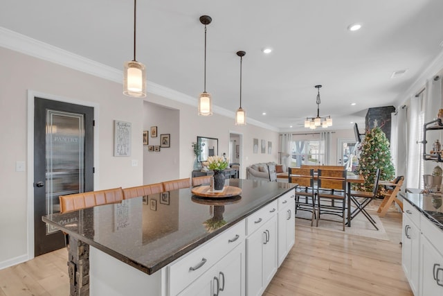 kitchen with light wood-type flooring, a center island, and hanging light fixtures